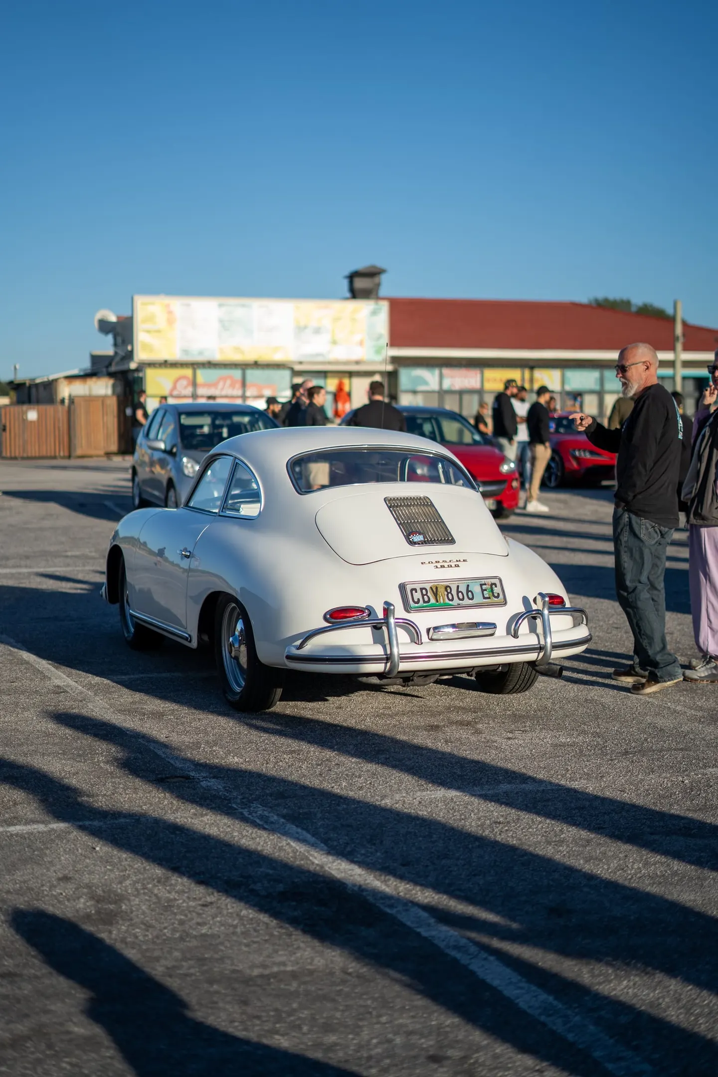 A white Porsche 356 in the car park