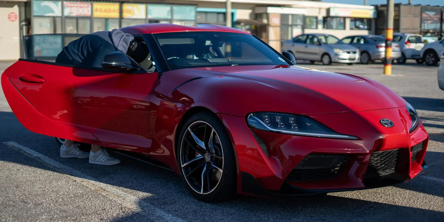 A red Toyota Supra with its bonnet open