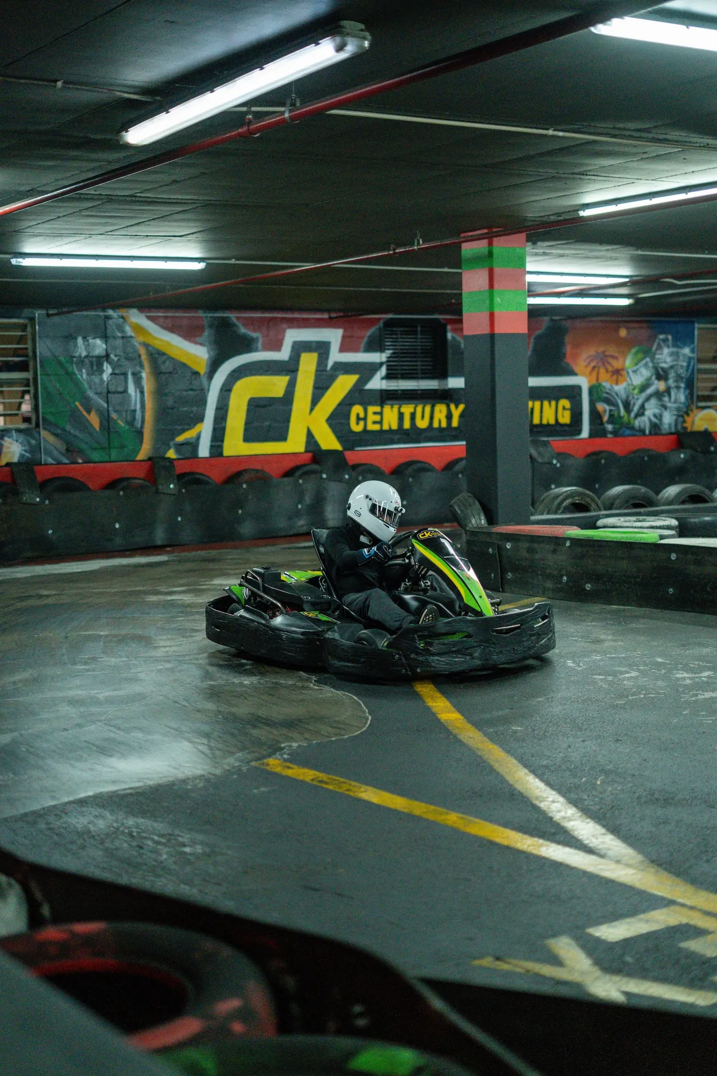 A kart through the hairpin under the Century Karting sign