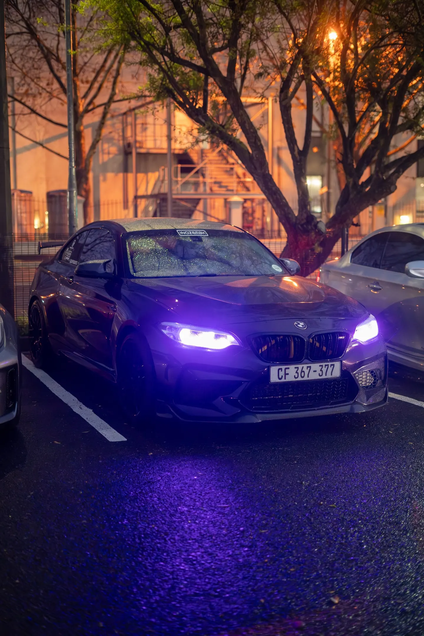 A BMW M2 with its headlights on at the start
