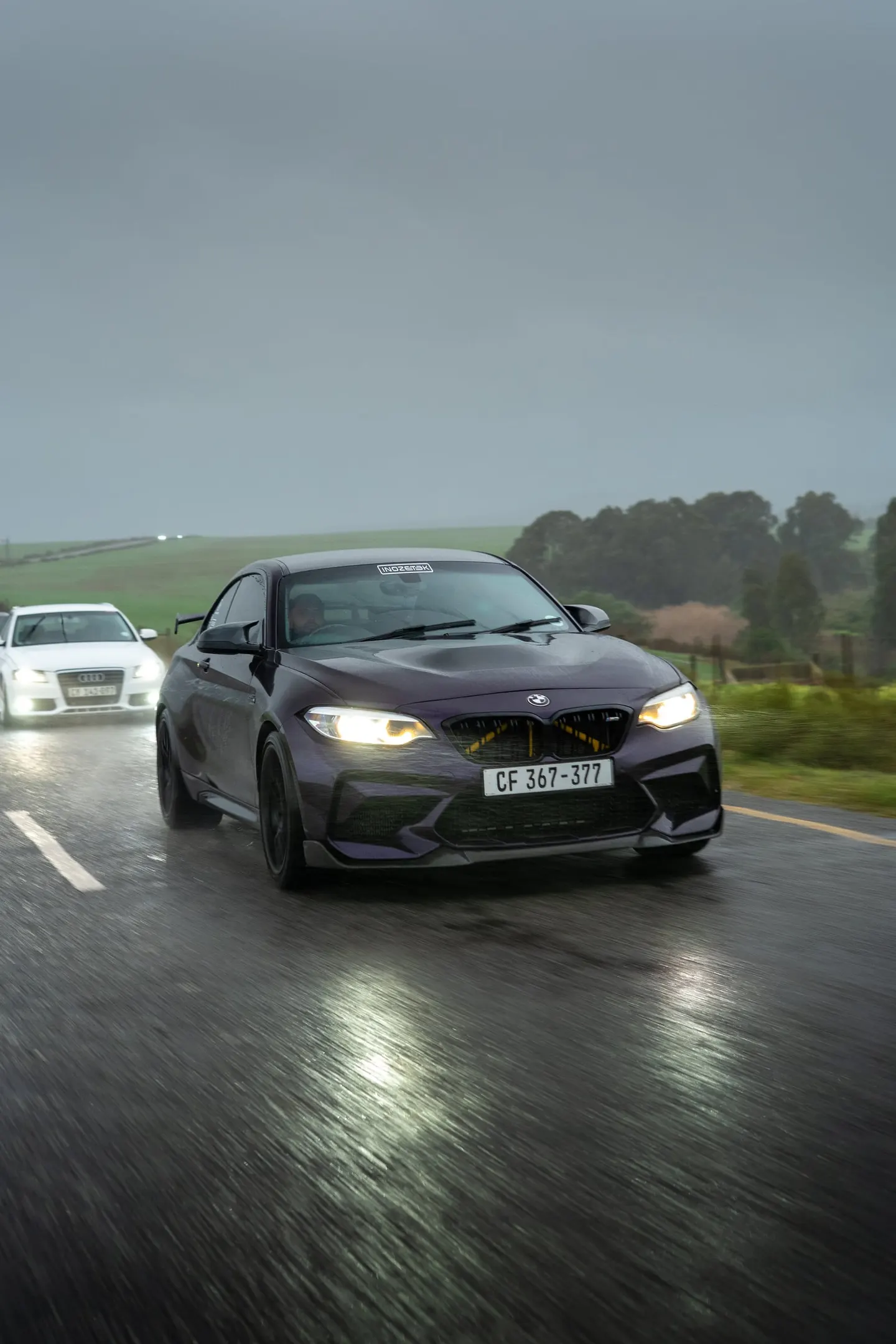 A BMW M2 on its headlights through the rain on the Run 3 route