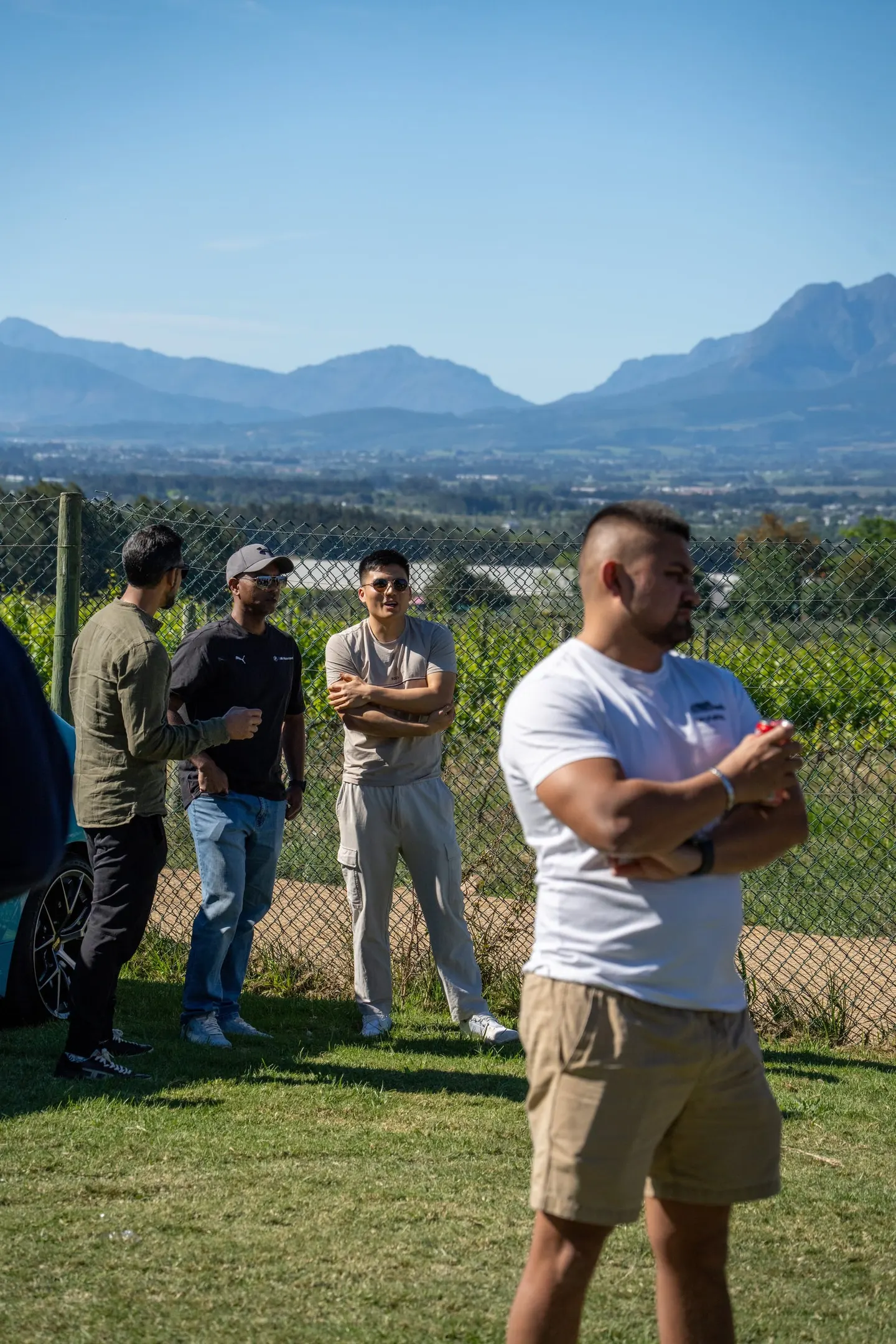 Drivers standing at the fence with the Franschhoek mountains behind